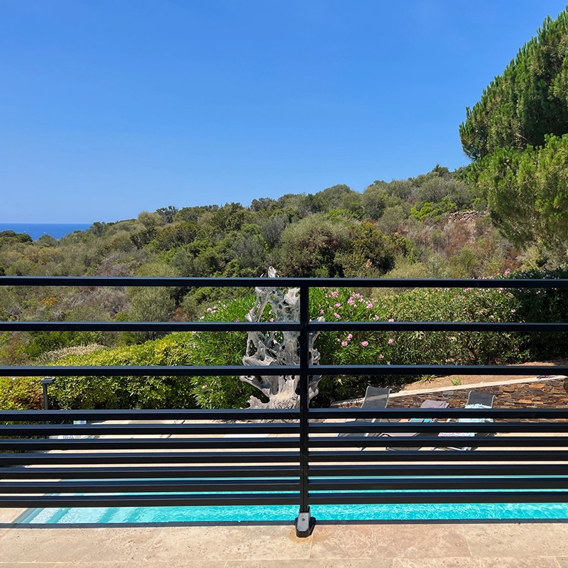 Garde-corps avec barreaux horizontaux noir, sur terrasse avec une piscine.