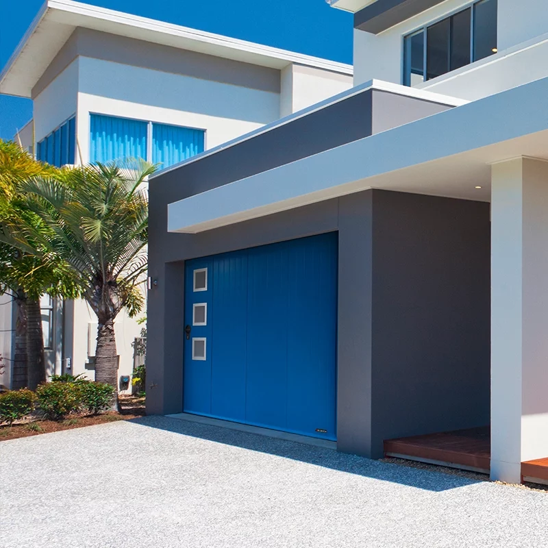 Une porte de garage bleue avec des décors carrés, dans une maison d'architecte.