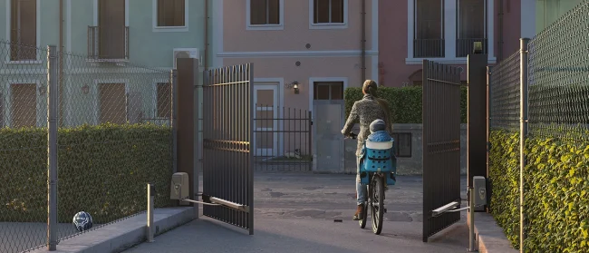 Un portail motorisé, avec un moteur à bras, laissant passer une femme