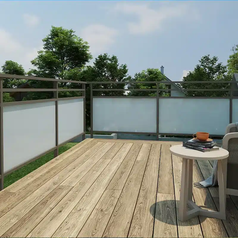 Un garde-corps marron en aluminium avec un vitrage opaque blanc sur une terrasse.